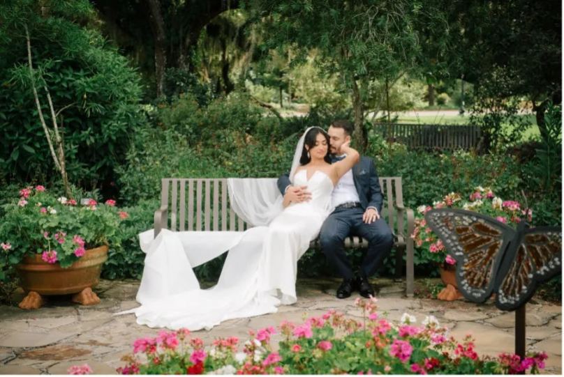 Bride And Groom Sitting On A Bench In The Outdoor